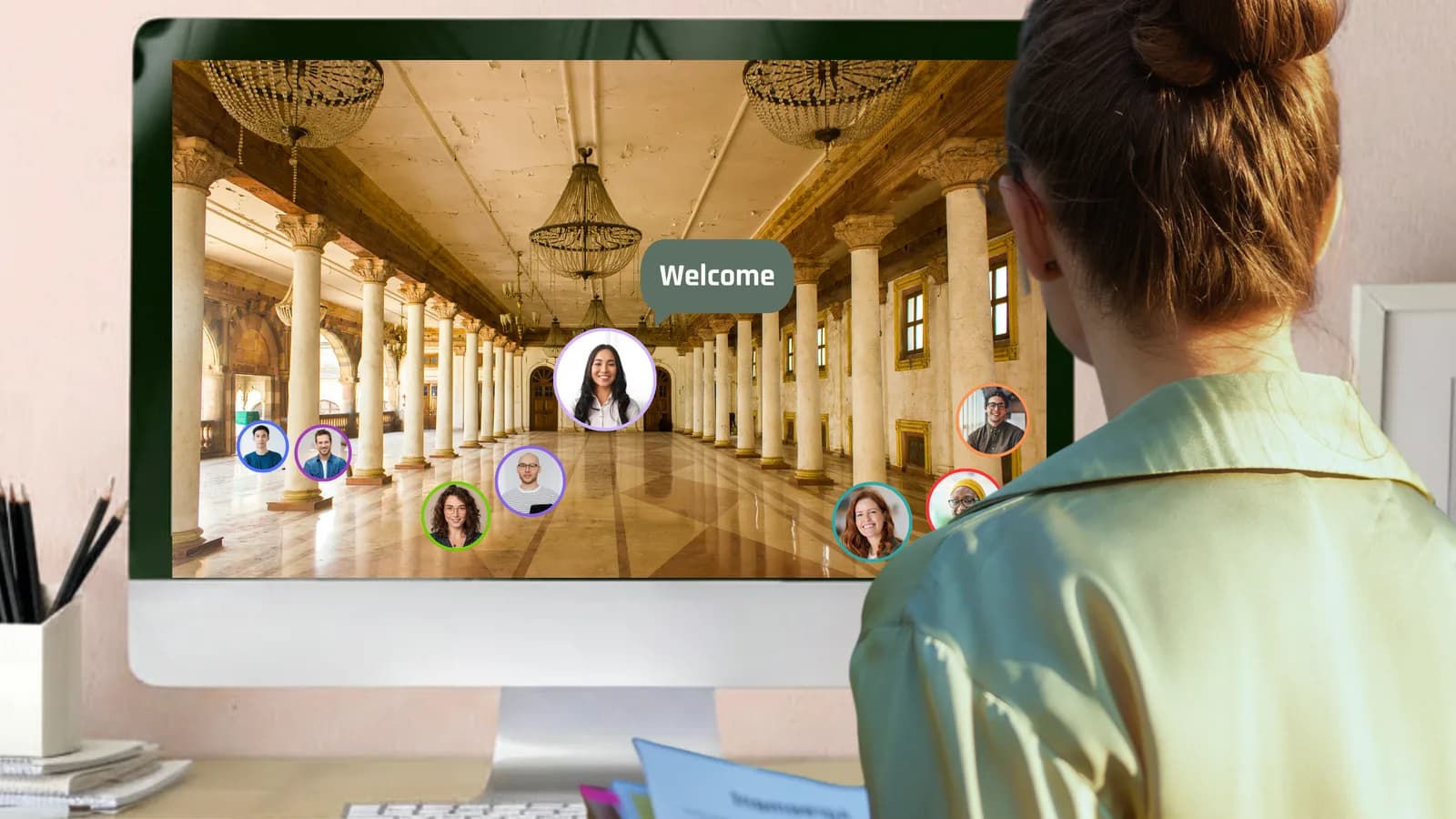 Medewerker volgt een online townhall waarin honderden collega's in beeld zijn, naast een laptop met de presentatie
