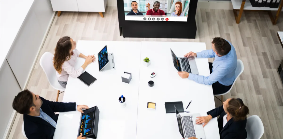 Hybride opstelling met deelnemers in de zaal en online tijdens een townhall van de directie