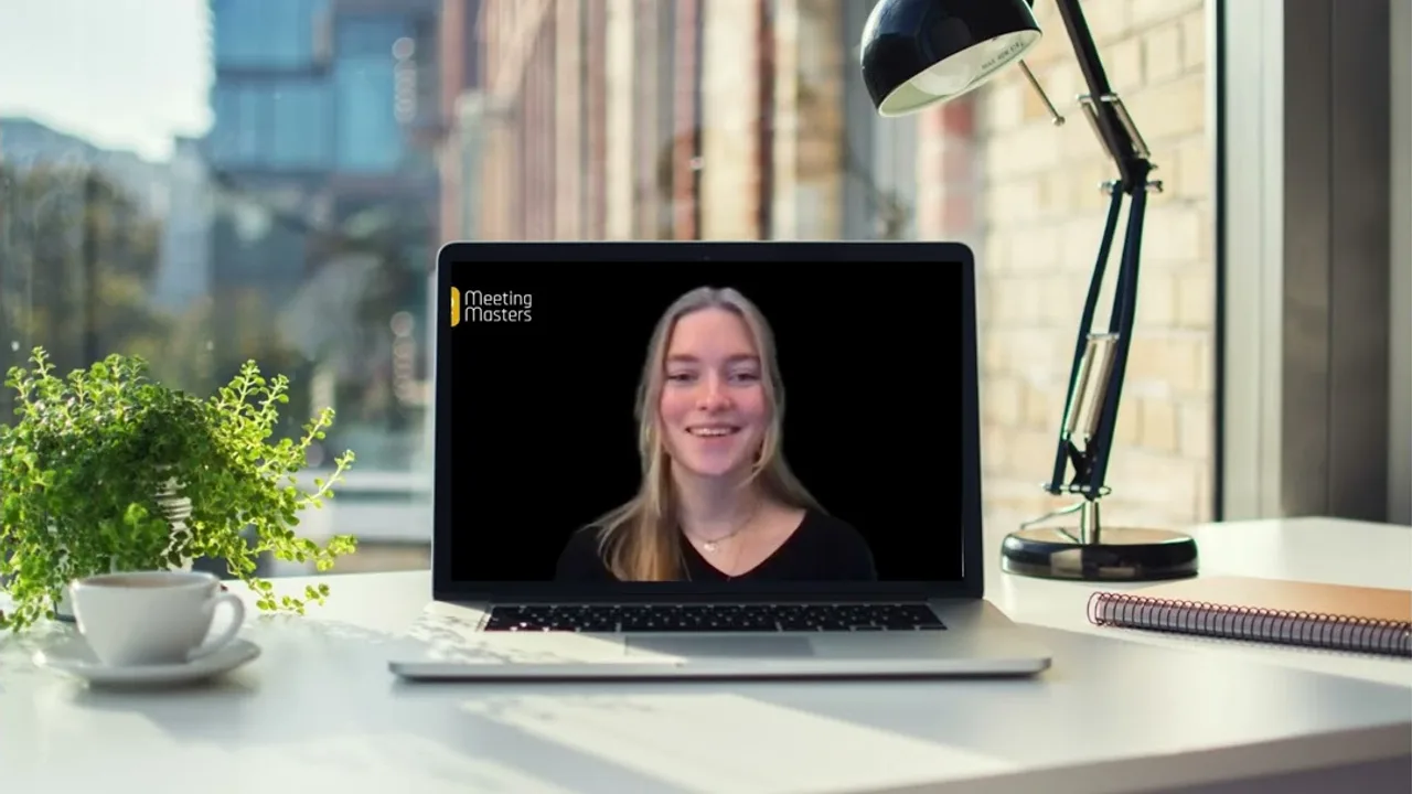 Een Meeting Master vertelt het manifest, te zien op een laptop op een bureau bij het raam
