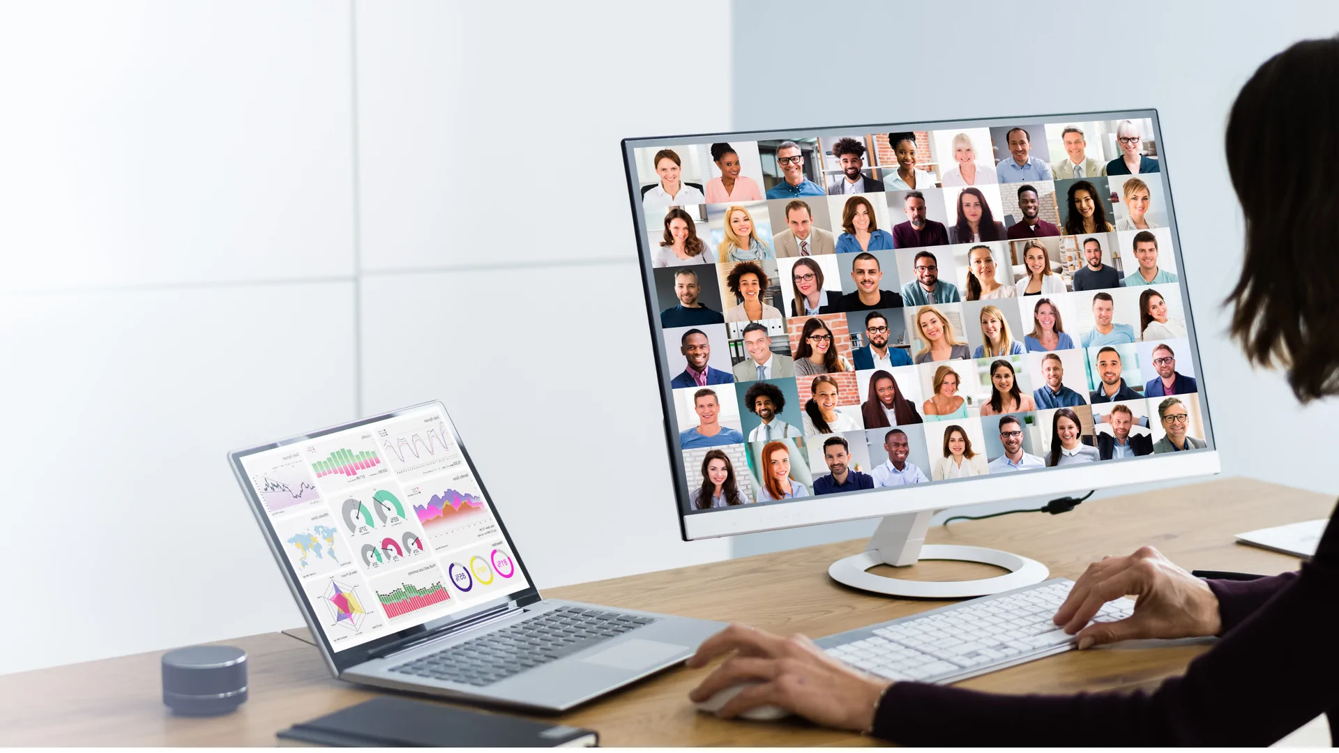 Deelnemer aan een online all-hands met het voltallige personeel in beeld op een groot scherm